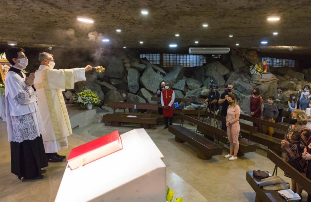 Interior da Capela Nossa Senhora da Gruta durante celebração católica em Alphaville