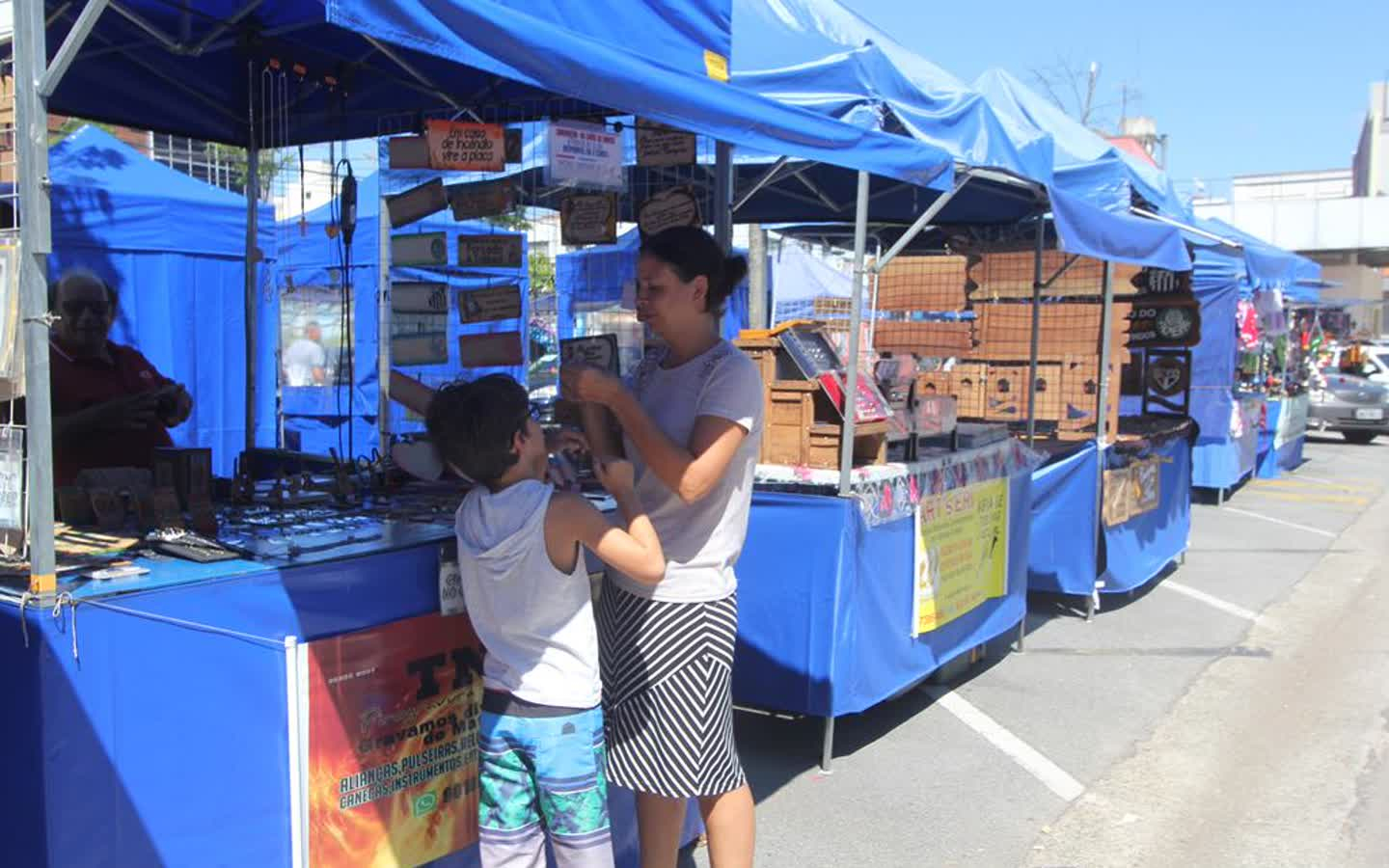 Feira de artesanato com barracas e famílias em Barueri