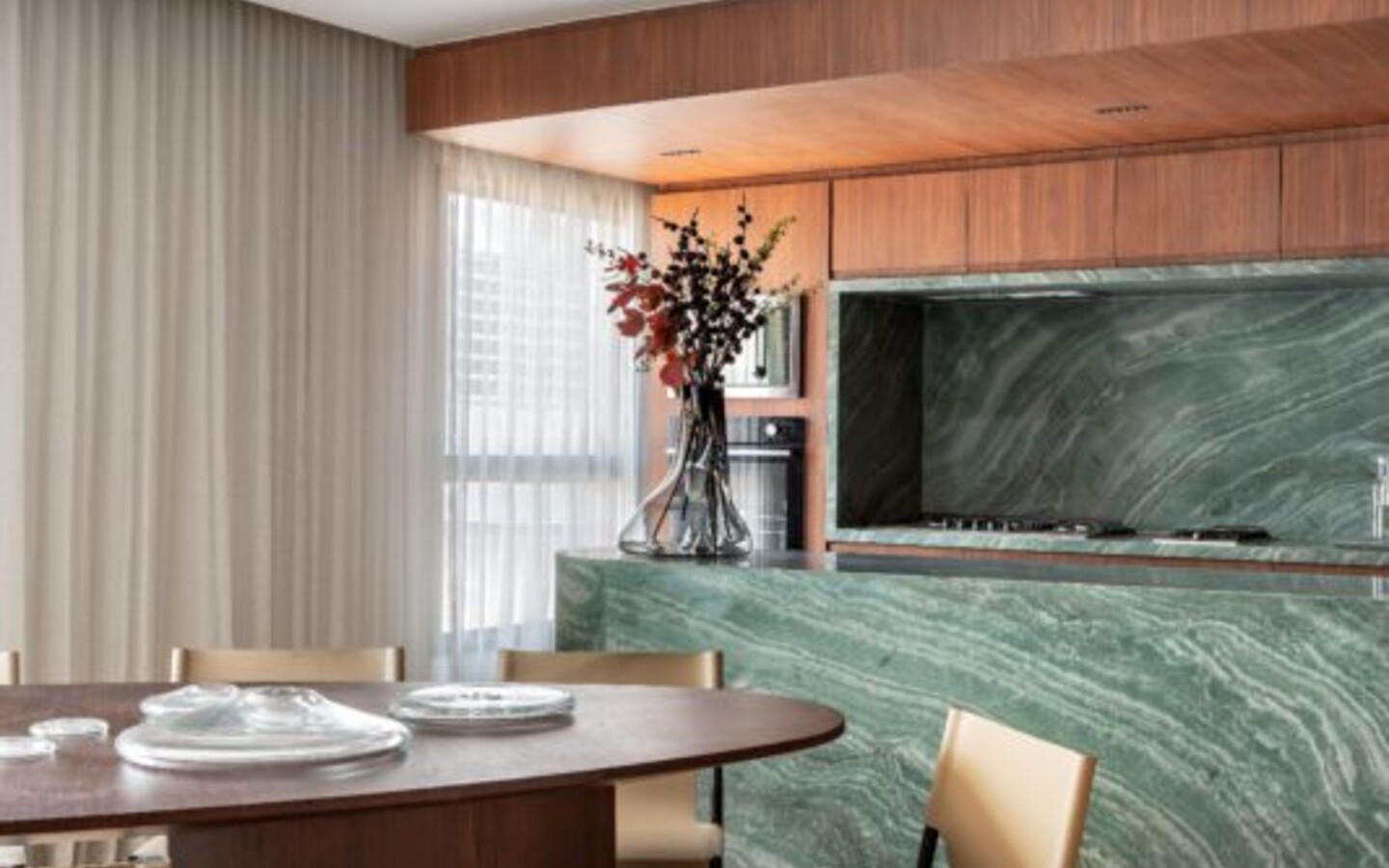 Cozinha com mármore verde e jantar no decorado do Joya Jardins, projeto Fernanda Marques. Imagem de referência; não corresponde necessariamente à planta anunciada.